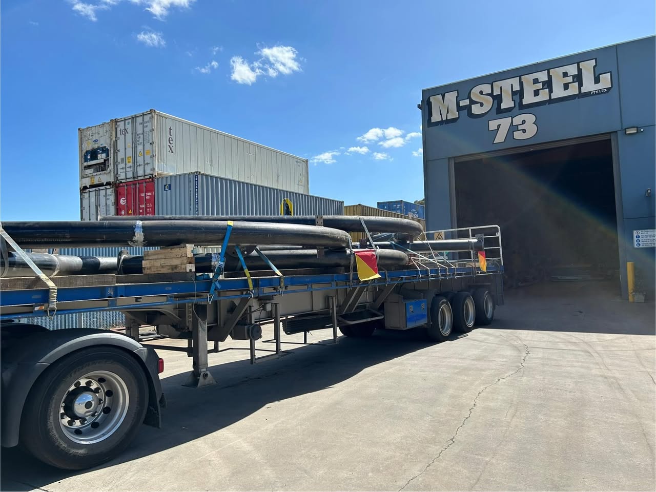 Flatbed truck with steel pipes at M-Steel warehouse